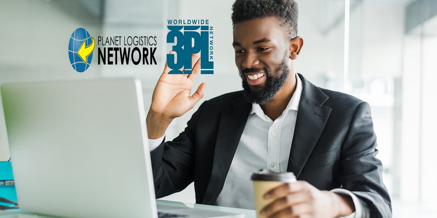 Young African manager with stubble sitting in front of open laptop wearing earphones while having video conference call with business partners